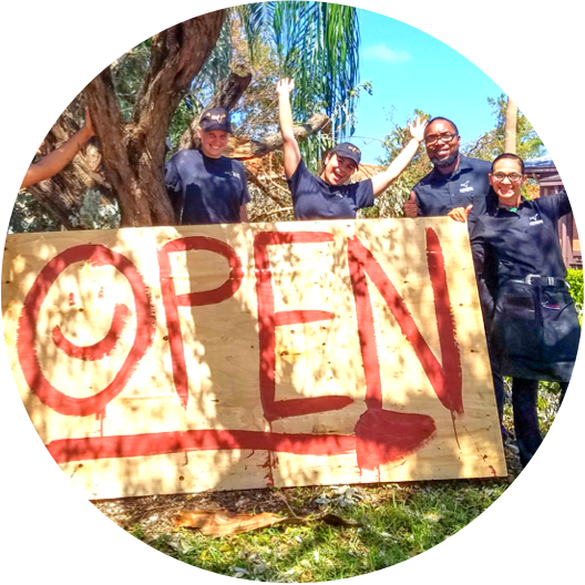 Handmade sign indicating restaurant is open following a hurricane